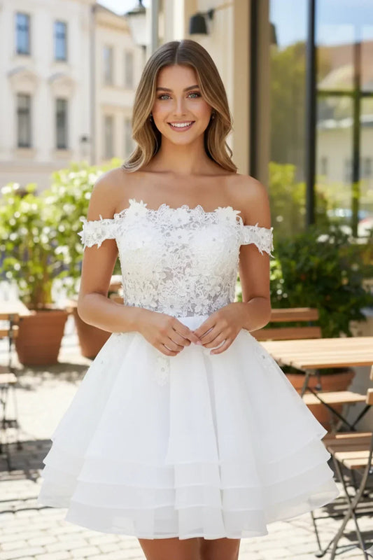 Woman in white off-the-shoulder A-line tulle prom dress with lace bodice, outdoor setting