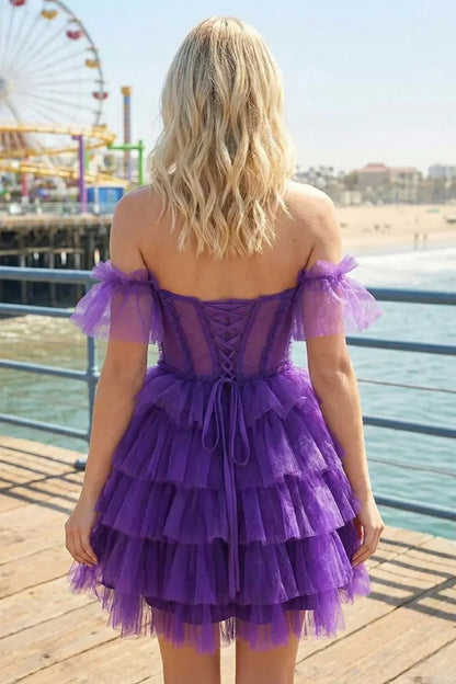Woman in a purple off-the-shoulder ruffle tiered homecoming dress by the beach