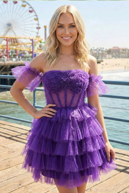 Woman in a purple off-the-shoulder lace-up ruffle tiered homecoming dress outdoors by the beach.