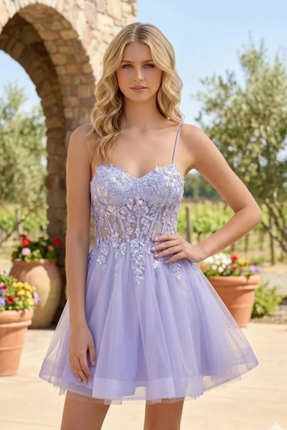 Model in a light purple A-line tulle homecoming dress with sequins and floral appliques