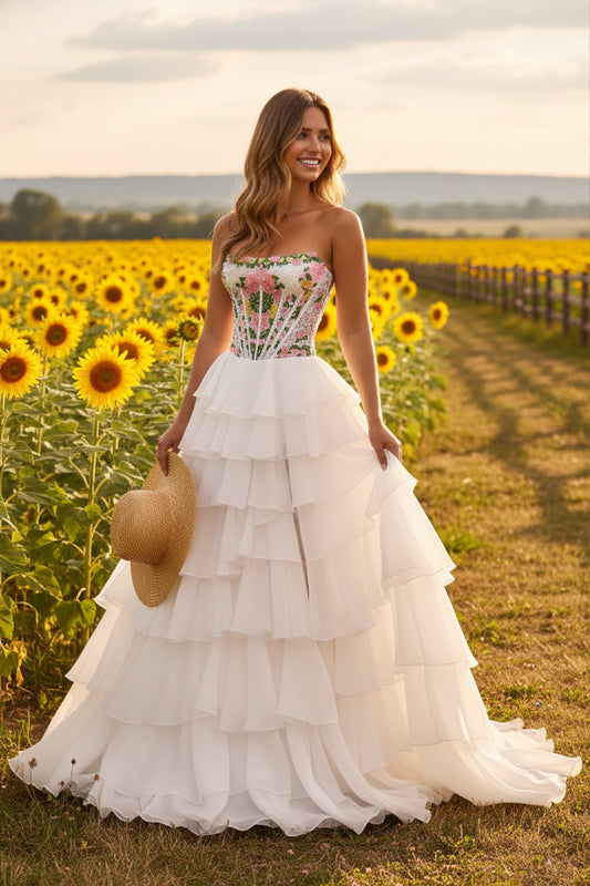 Sevoba strapless floral corset tiered A-line prom dress, white layered skirt, front view in sunflower field