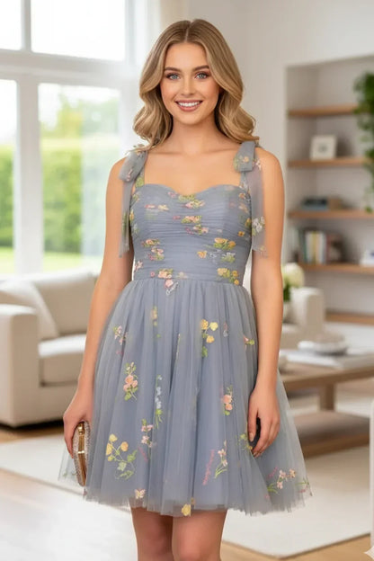 A-line sweetheart tulle short homecoming dress with floral embroidery, worn indoors