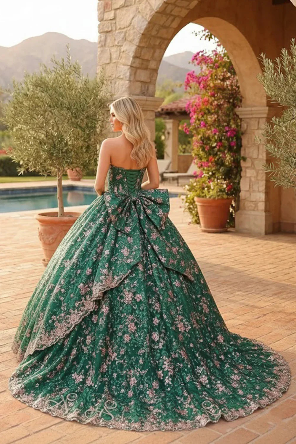 Green glitter ball gown with floral embroidery, large back bow, outdoor event setting