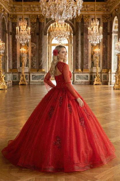 Woman in elegant red tulle ball gown with lace details, in a grand chandelier-lit hall