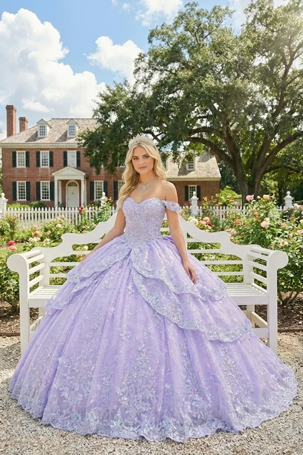 Woman in lilac ball gown with floral embroidery, tiara, and necklace, seated on white bench outdoors