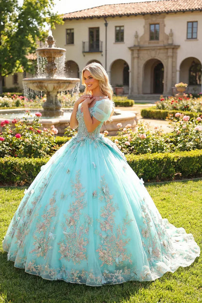Elegant aqua blue ball gown with floral embroidery and 3D butterflies, worn outdoors near a fountain.