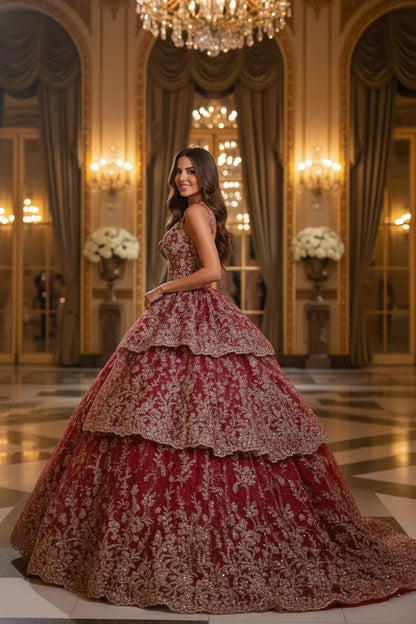 Woman in elegant layered red and gold ball gown with floral embroidery in a grand hall