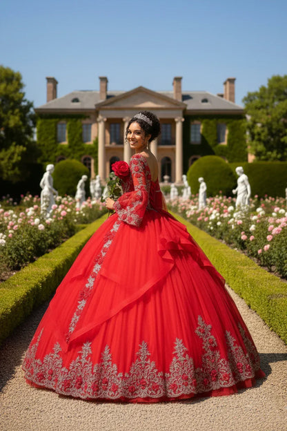 Woman in a red ruffled tulle ball gown with silver beading, holding a rose in a formal garden
