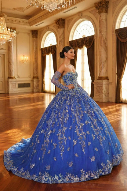 Woman in elegant blue glittery ball gown with sheer sleeves, gold embroidery, ballroom setting