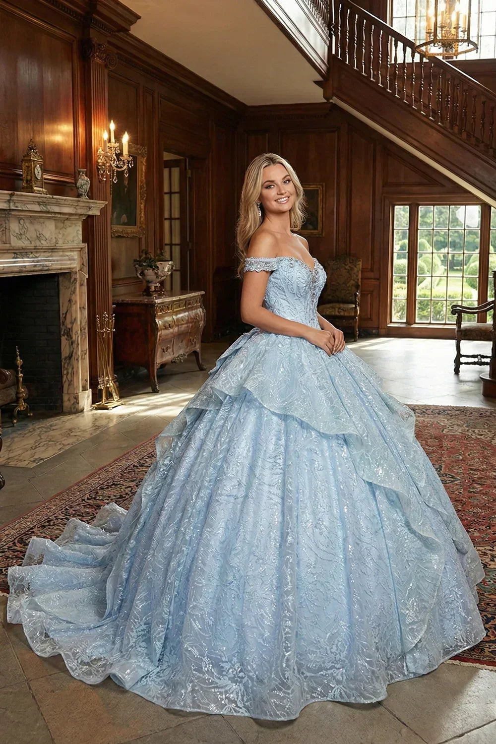 Woman in a blue layered ruffled ball gown with embroidery, cold shoulder design, in elegant room