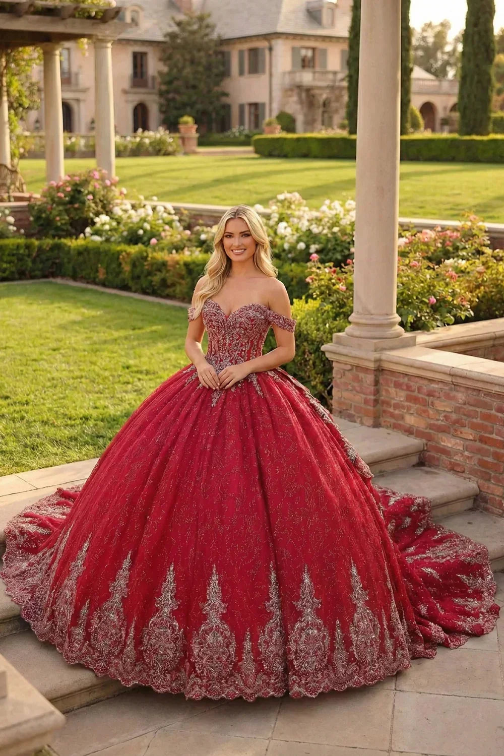 Woman in a red embroidered ball gown with sweetheart neckline standing in a garden