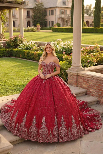 Woman in a red embroidered ball gown with sweetheart neckline standing in a garden