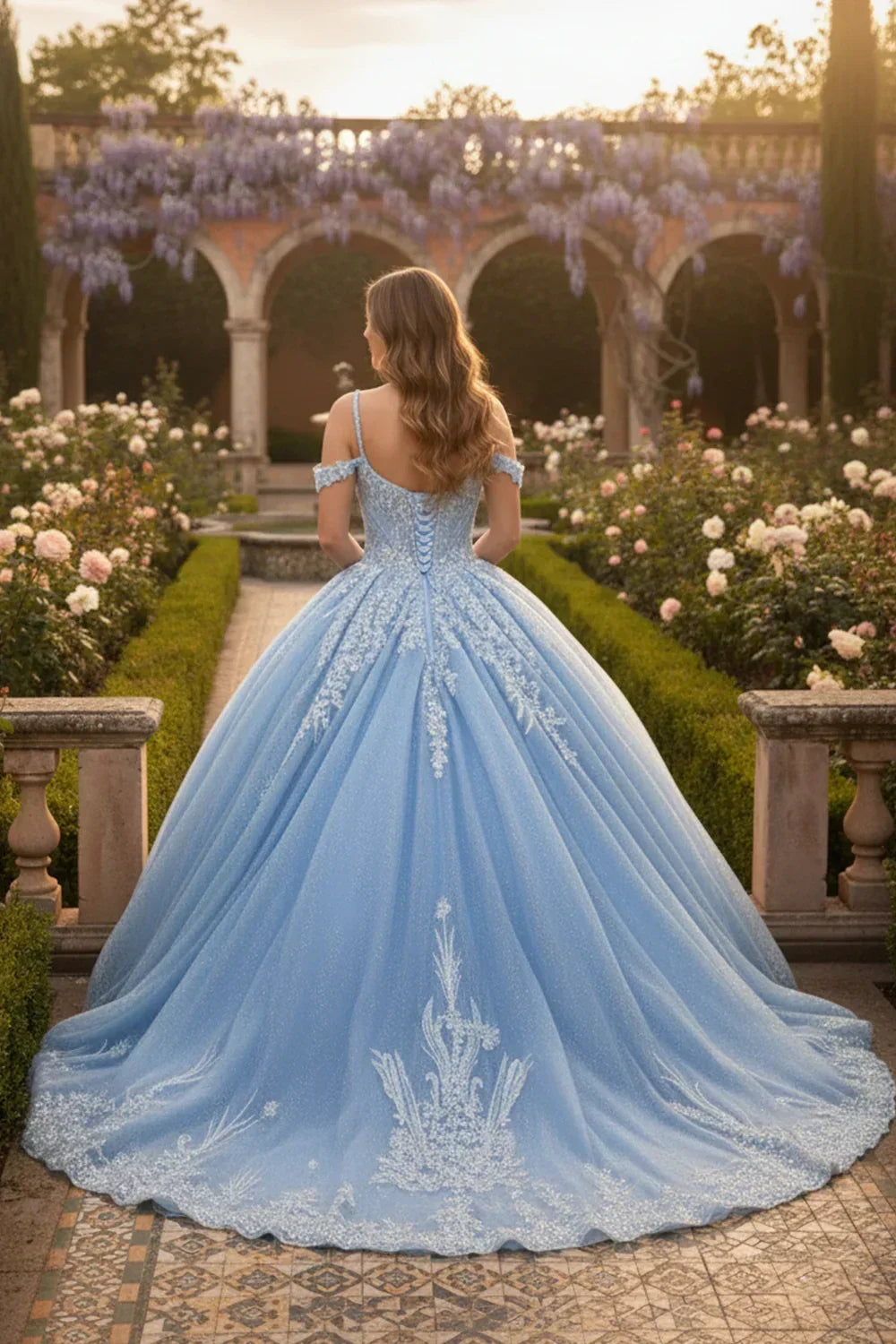 Woman in a blue off-shoulder lace ball gown with embroidery, standing in a floral garden.