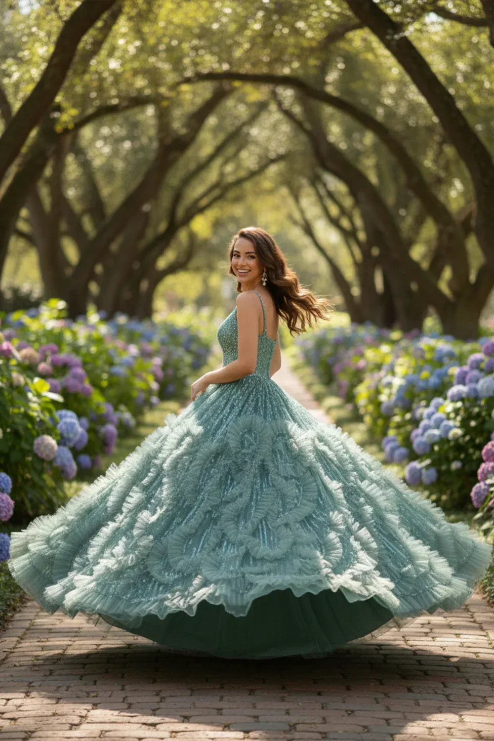 Woman in blue textured ruffle ball gown with spaghetti straps in a garden with hydrangeas