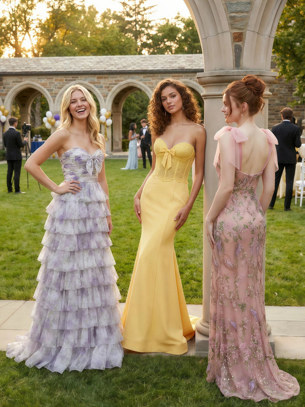 Sevoba prom night group photo, three friends in pastel formal dresses posing at an outdoor event.