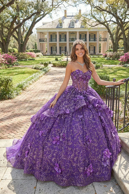 Woman in a purple 3D floral ball gown with lace details, standing outdoors near a mansion