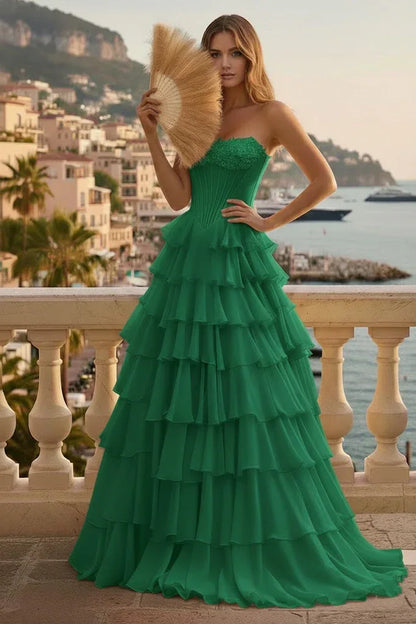 Woman in a strapless green tiered ruffle corset A-line prom dress with scenic coastal background