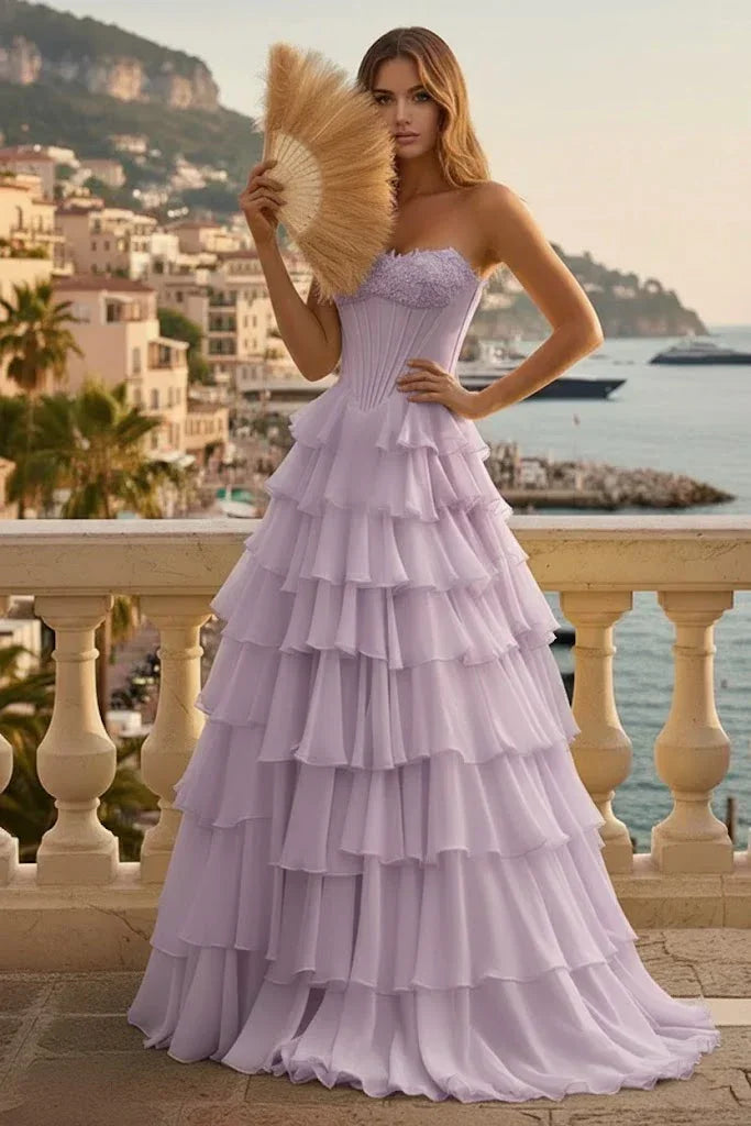 Woman in lilac tiered ruffle corset prom dress with lace-up back on a balcony with seaside view