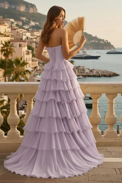 Back view of woman in lilac tiered ruffle A-line prom dress with lace-up corset, seaside terrace