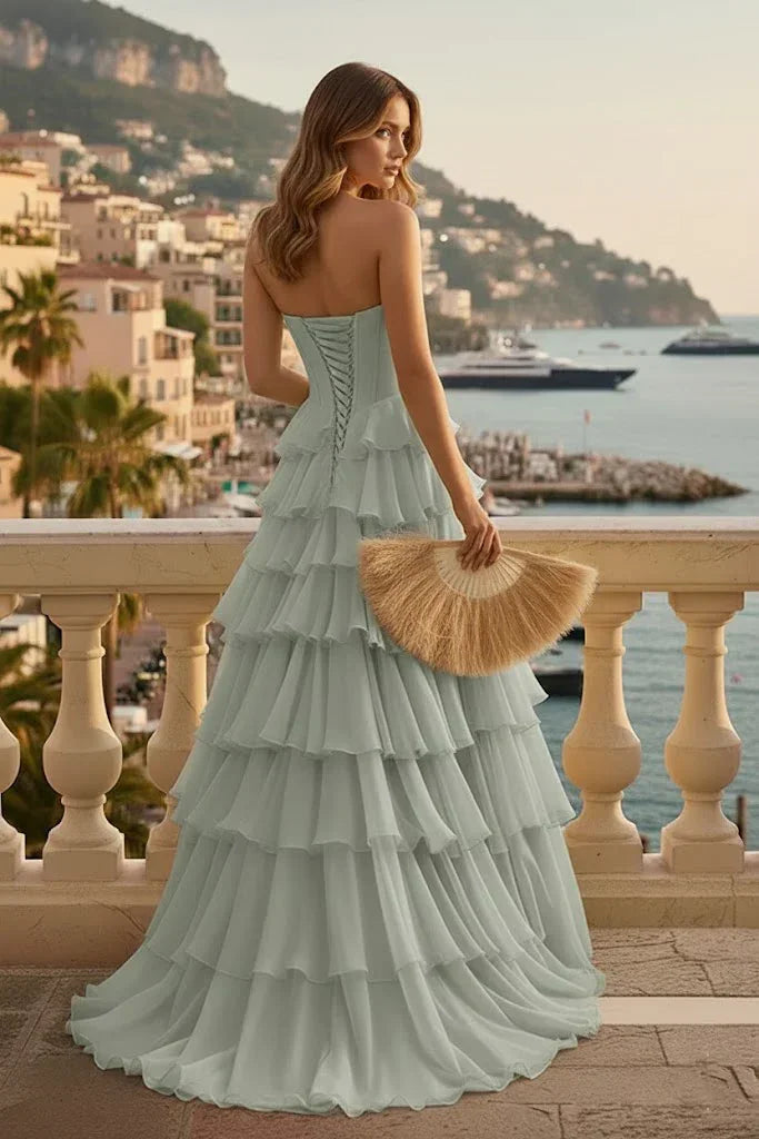 Woman in tiered ruffle A-line prom dress with lace-up back on seaside terrace