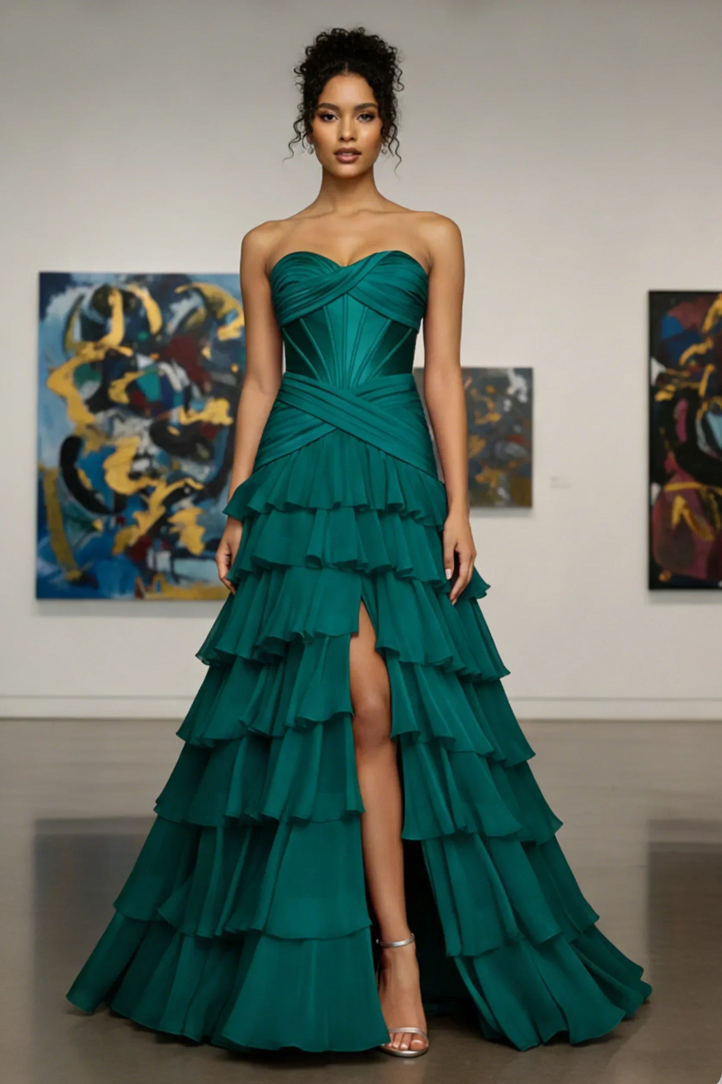 Woman modeling strapless emerald green ruffled evening gown with high slit, in art gallery